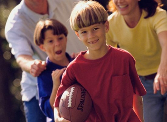 Foster Children Having Fun In Park With Foster Parents